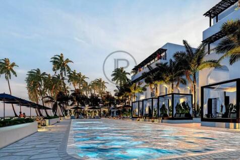 A luxury beachfront resort features an infinity po