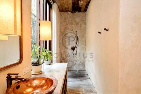 The image shows a rustic bathroom with a stone-til