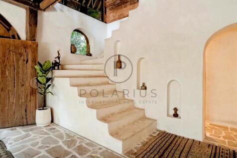 A rustic interior features a staircase with built-