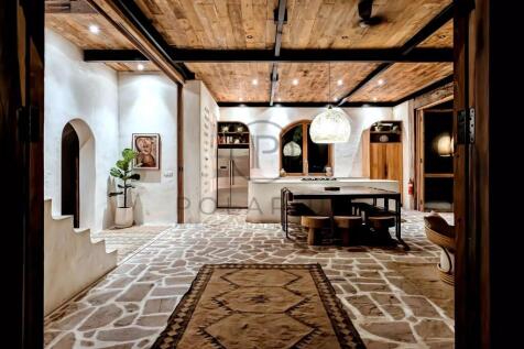 A rustic, modern kitchen with stone flooring, a wo
