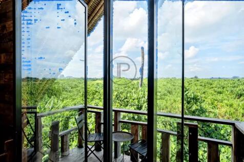 A room with large glass windows offers a scenic vi