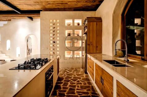 A rustic kitchen with a stone floor features a mod