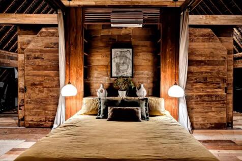 A cozy bedroom with warm wooden walls, a large bed
