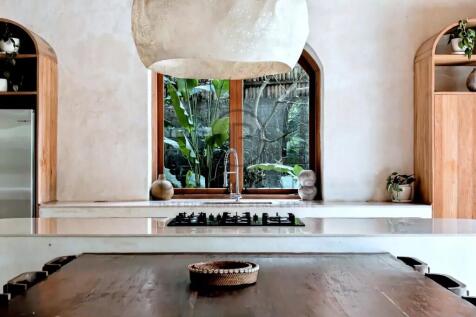 A modern kitchen with a wooden dining table, a lar