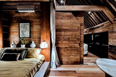 A rustic wooden bedroom with a cozy bed, decorativ