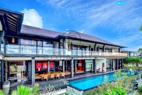 A luxurious modern villa features a large pool, sp