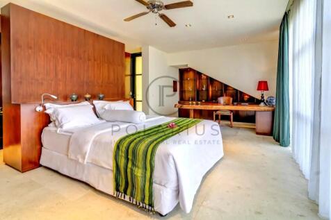A cozy bedroom features a large bed with a green-s
