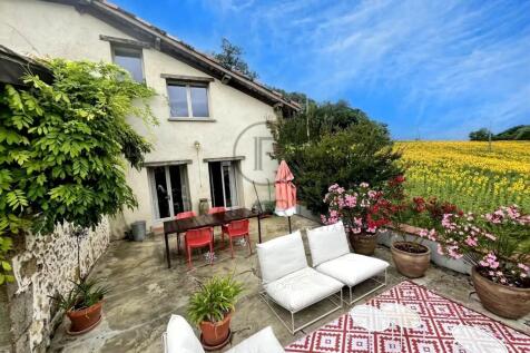 A cozy courtyard with white outdoor furniture and 