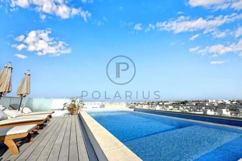 Rooftop pool with lounge chairs and umbrellas unde