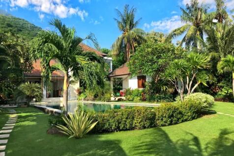 A tropical house with a swimming pool, surrounded 