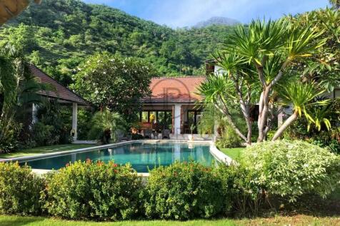 A luxurious villa with a swimming pool is surround