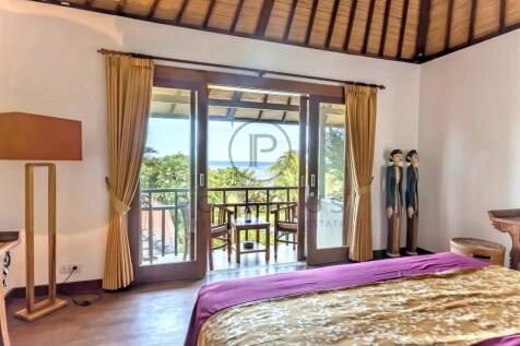A cozy bedroom with a wooden ceiling, featuring a 