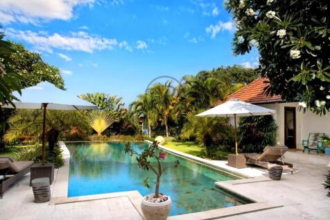 A serene tropical poolside scene with lush greener