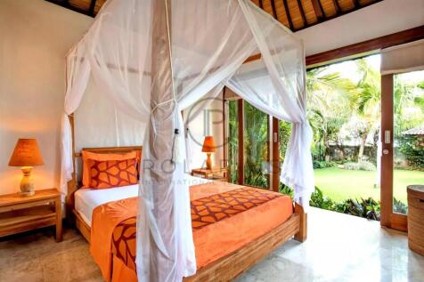 A cozy bedroom featuring a canopy bed with sheer d