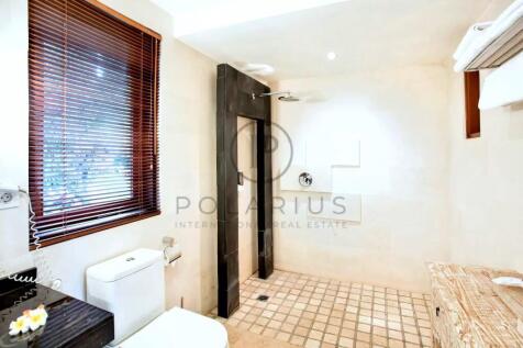 A modern bathroom with a walk-in shower, white toi