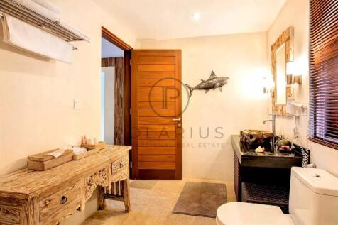 A rustic bathroom features a wooden vanity, a clos