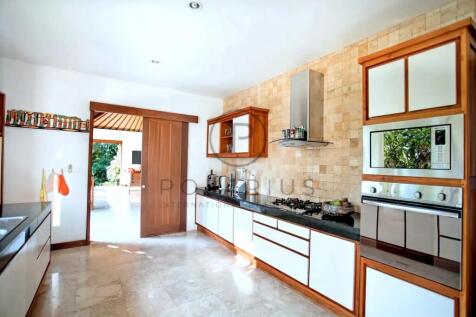 A modern kitchen with white cabinets, wooden accen