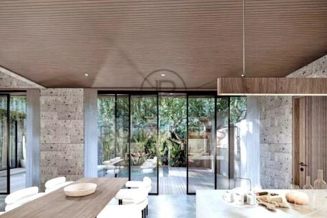 A modern dining area features a wooden ceiling and