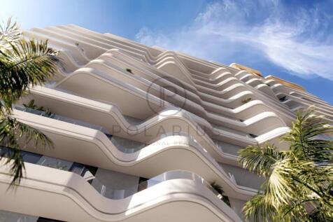 The image shows a modern, curvy high-rise building