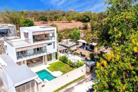 Modern multi-story house with a pool, surrounded b