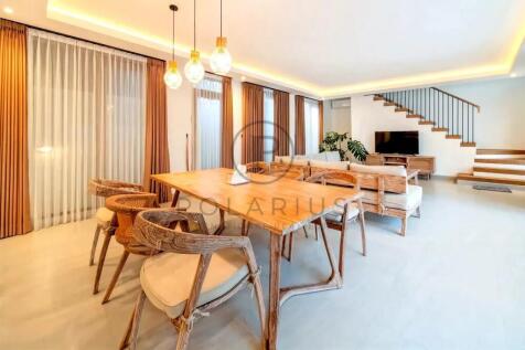 A modern living and dining area with a wooden dini