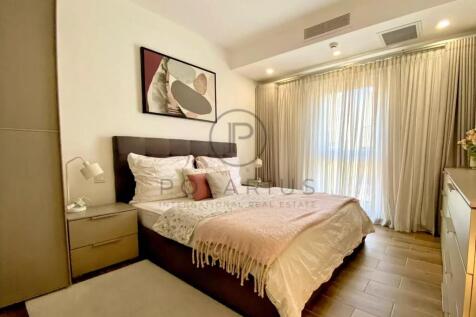 A cozy bedroom with a double bed, accent pillows, 