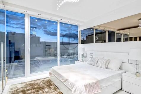 A modern bedroom with large windows showing a view