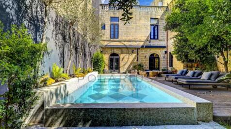 A charming courtyard features a rectangular pool s