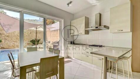 A modern kitchen with light-colored cabinets and a