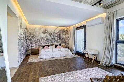 A modern bedroom with a large bed, tropical-themed