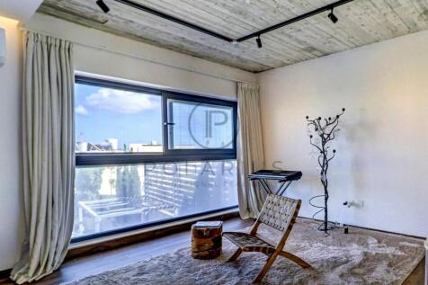 A minimalist room features a large window with lig