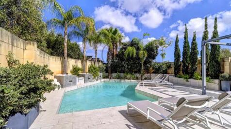A tranquil outdoor swimming pool surrounded by pal
