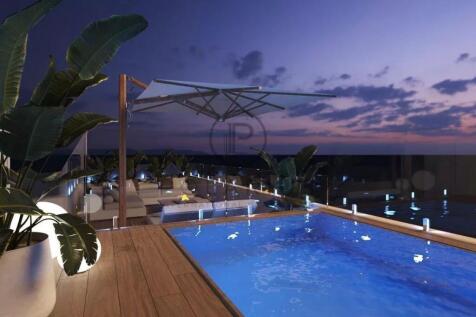 Rooftop pool at sunset with lounge chairs, large p