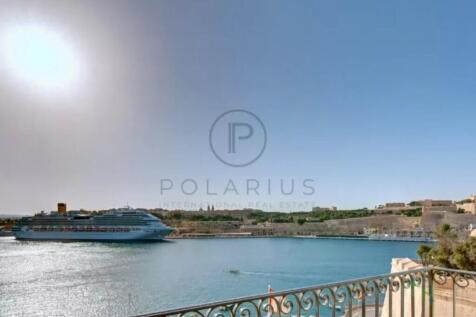 A sunny coastal scene featuring a large cruise shi