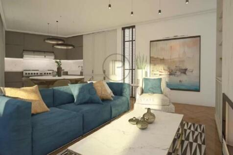 A modern living room with a blue sofa, beige chair