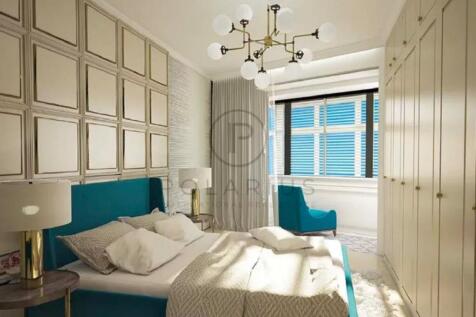 A modern bedroom with a teal bed and chair, beige