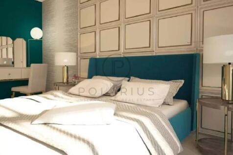 A modern bedroom with a teal upholstered bed, soft