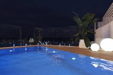 A serene nighttime pool scene with glowing lights,