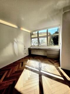 Bright room with angled windows, wooden herringbon