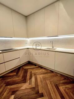 A modern kitchen with minimalist white cabinets, a