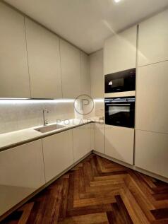 A modern kitchen with sleek, handleless cabinets,