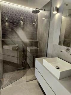 The image shows a modern bathroom with a walk-in s