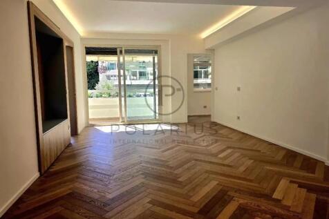 A spacious, empty room with herringbone wood floor
