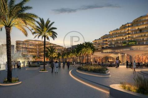 A beautifully lit waterfront promenade with palm t