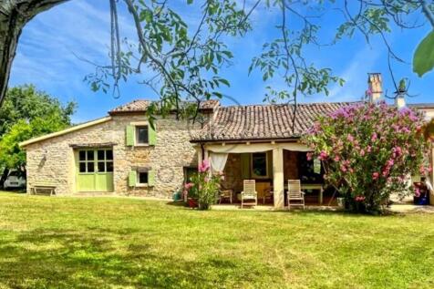 A charming stone house with a sloped, tiled roof i