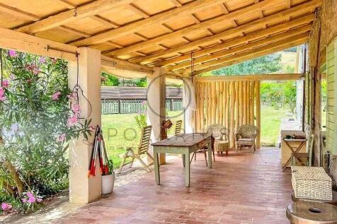 A rustic outdoor patio with a wooden roof, featuri