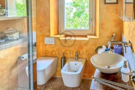 A small, stylish bathroom with warm orange walls f