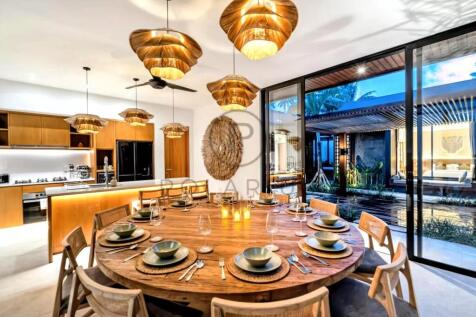 A modern dining room with a large round wooden tab