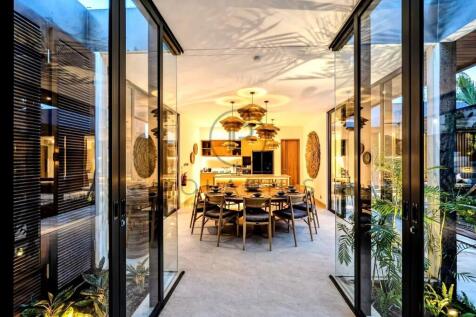 A modern dining room with a long table and chairs