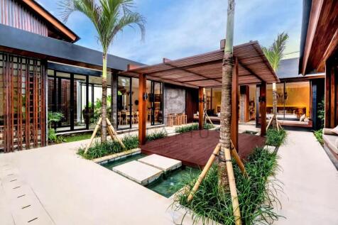 A modern courtyard features a wooden deck with a p